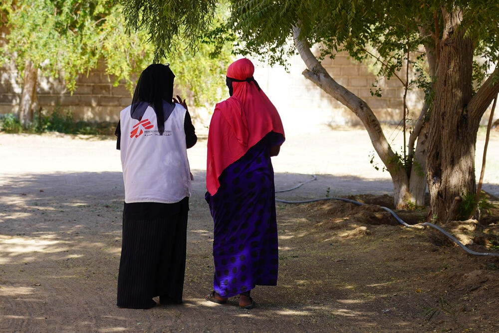 An MSF staff member talking with a 20-year-old Ethiopian woman who has become stuck in Marib on her way to Saudi Arabia
