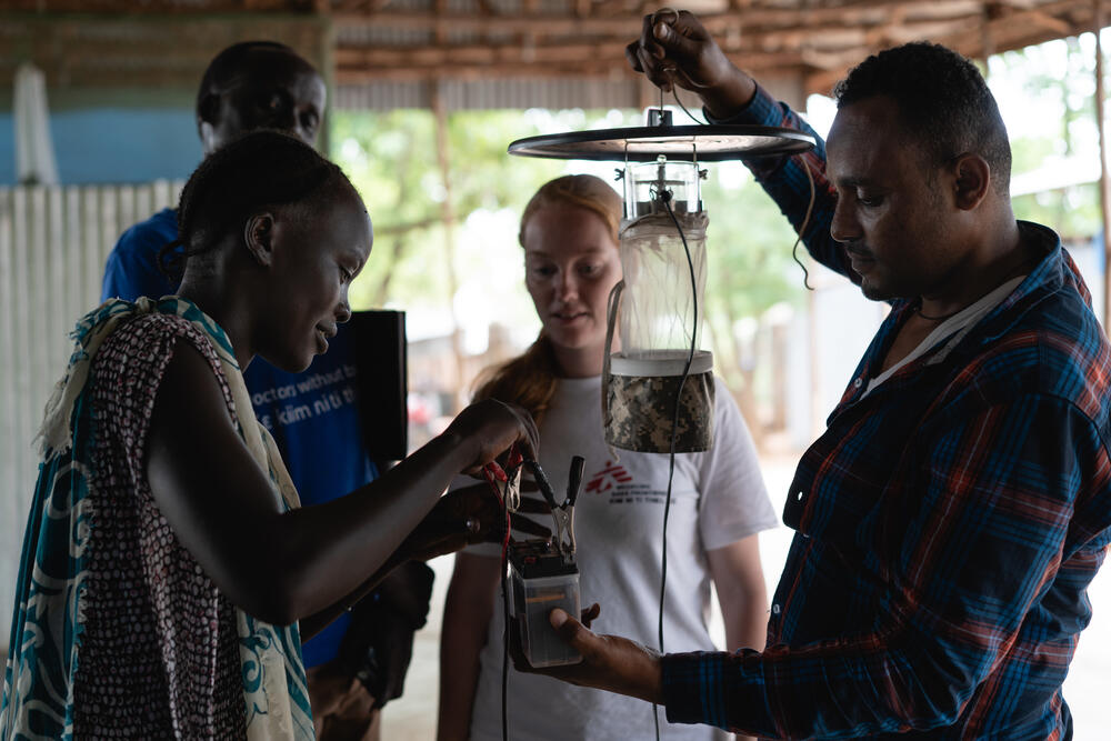 Jeanine (centre) explains the setup and functioning of mosquito traps to the MSF outreach workers that will distribute them to the selected refugee households.