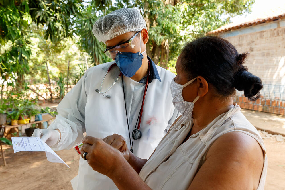 MSF doctor Pedro Ueda explains a prescription to a patient in Mato Grosso do Sul, Brazil. She and her husband contracted COVID-19 and kept isolated at home, where they received visits from the health team to monitor their recovery.