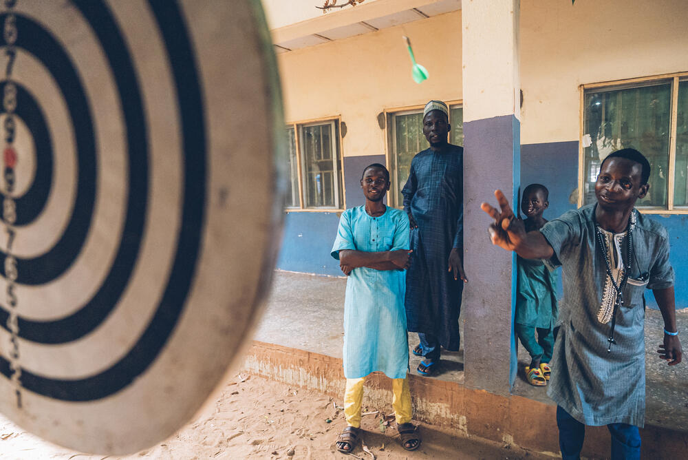 Rabiu, a 20-year-old noma survivor, plays darts in the courtyard of the Sokoto Noma Hospital