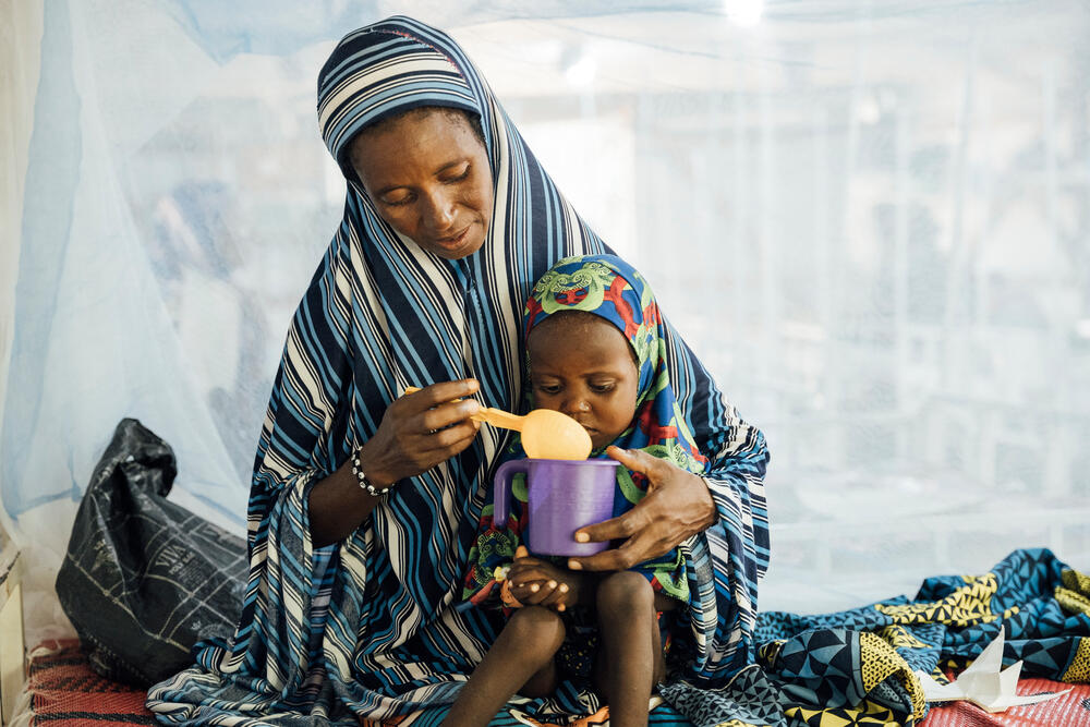 Hadisa Maman feeding her daughter while on a malnutrition ward in Magaria, Niger