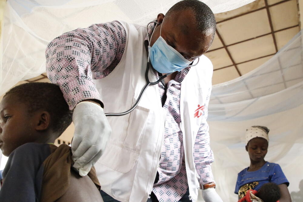 Theophile, an MSF emergency team doctor, examines a child with measles at the Bosobolo general referral hospital