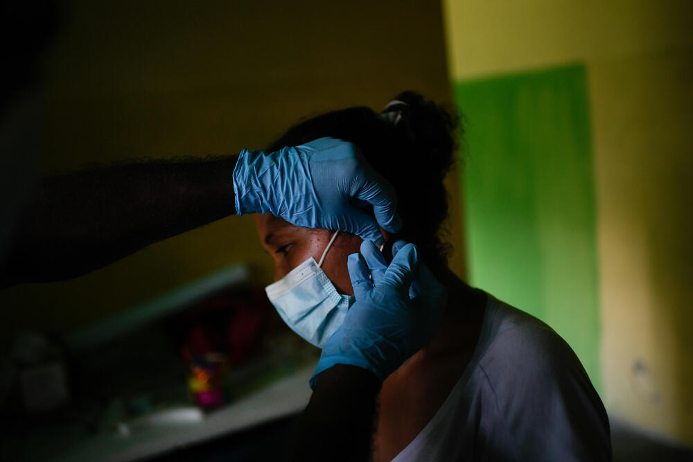  Healthcare staff take a blood sample from the earlobe of a patient with malaria symptoms