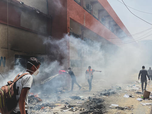 Photograph taken near Nasser Hospital featuring men dousing fires, 23 April, 2024