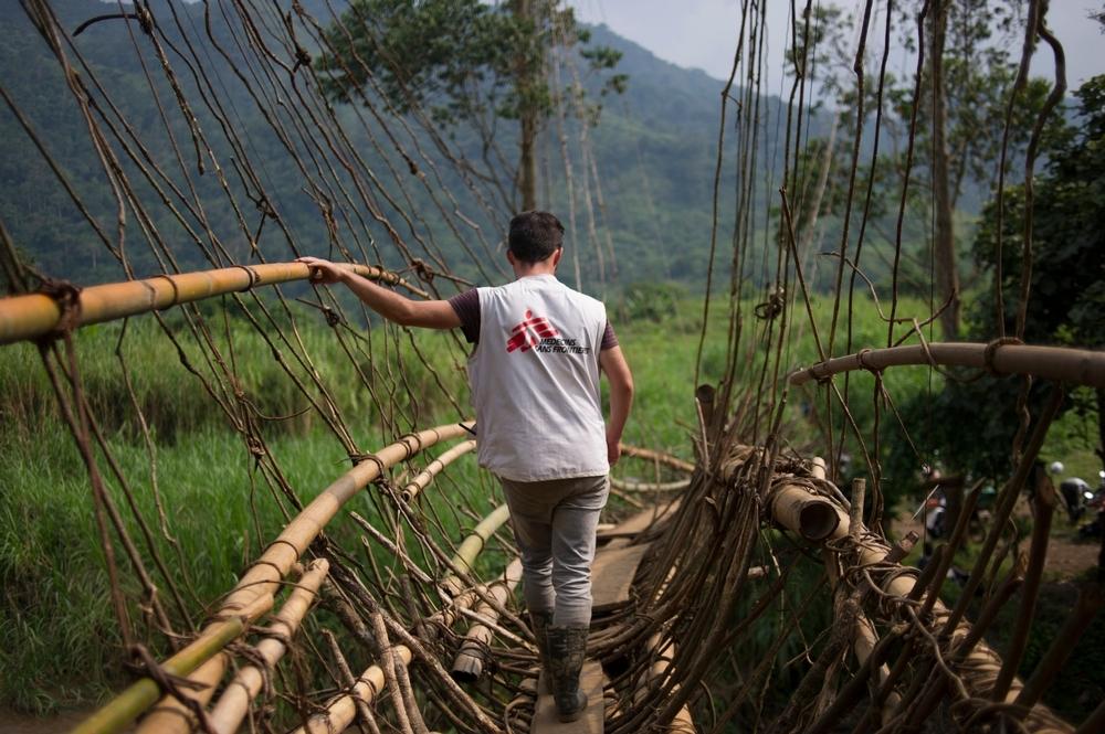 MSF emergency nurse Maarten Bullens traverses a makeshift bridge to the remote village of Lukweti, DRC, where MSF's mobile clinic team delivers healthcare. 