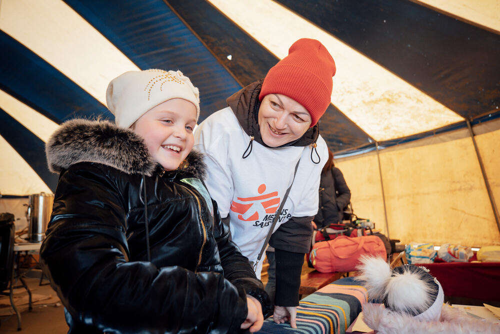 An MSF community health worker speaking to a child at a reception centre in Palanca, Moldova, near the border with Ukraine