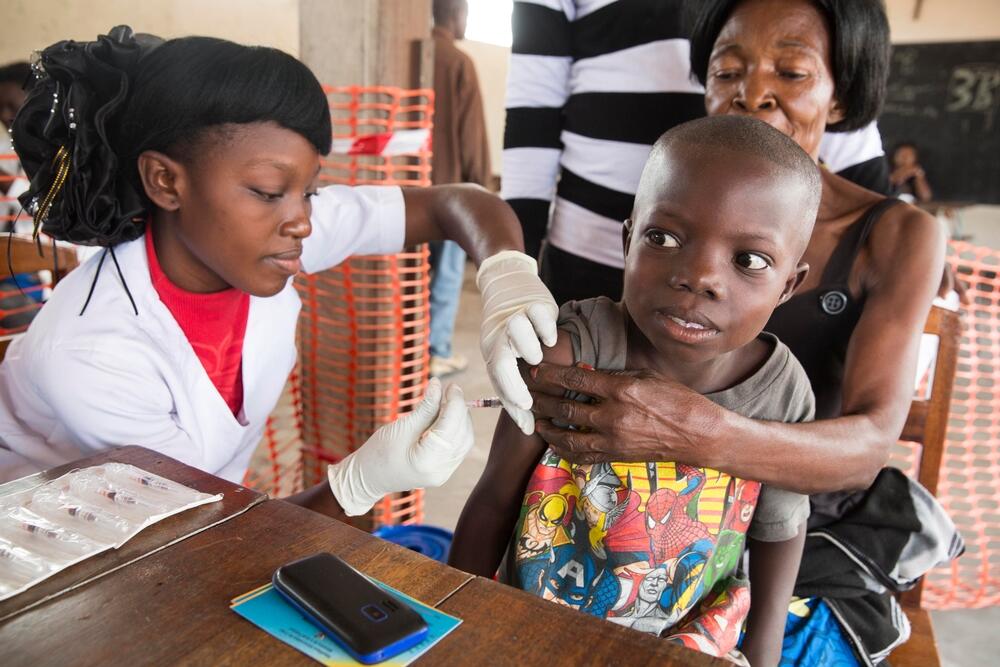 An MSF medical team member vaccinates a young child for yellow fever at a school in the Kikimi area of Kinshasa, DRC