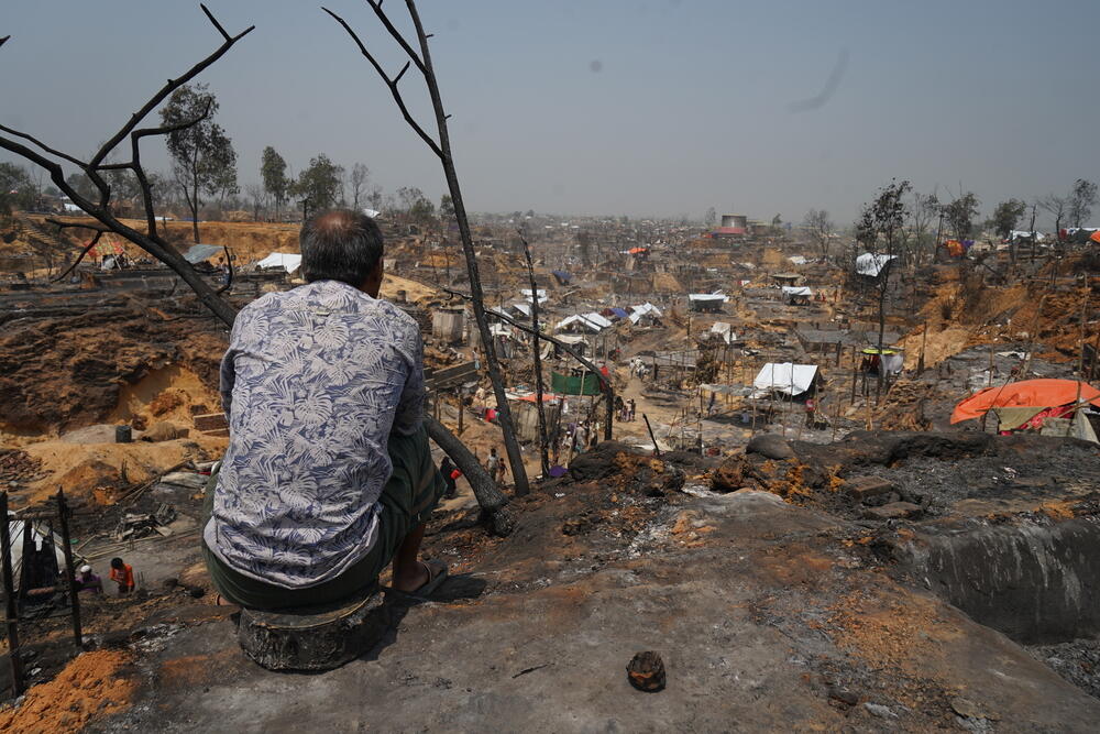 A man looks over a part of the vast refugee camp hit by the fire. 