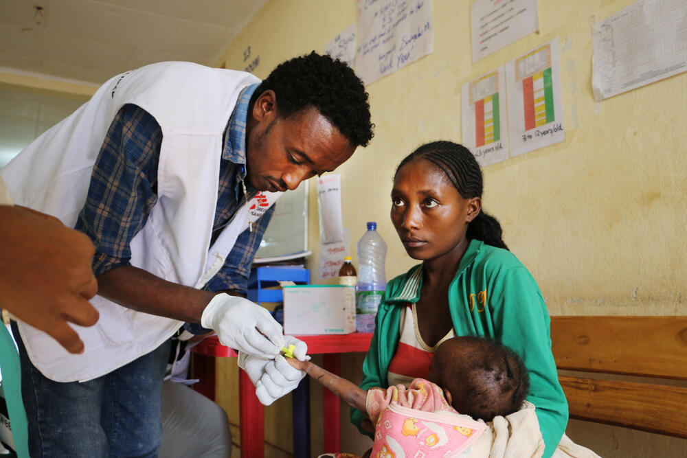 An MSF staff member prepares to attach an IV line to a malnourished child at the stabilisation centre in Gedeb hospital, in Gedeo, south Ethiopia.