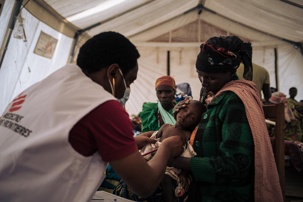 MSF Doctor Benjamin Safari examines an 11-month-old child in the paediatric ward tents of the MSF field hospital in Rhoe camp
