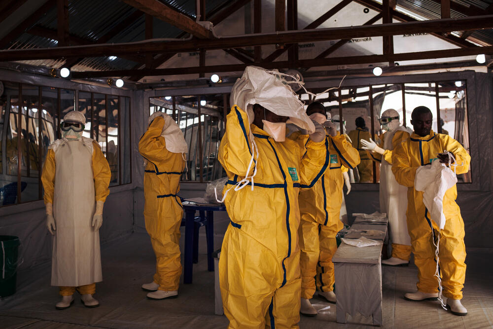 Health workers putting on their personal protective equipment before entering the red zone of the Ebola treatment centre