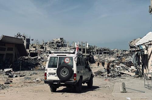 An MSF vehicle passes in front of ruined buildings in Jabalia, Gaza