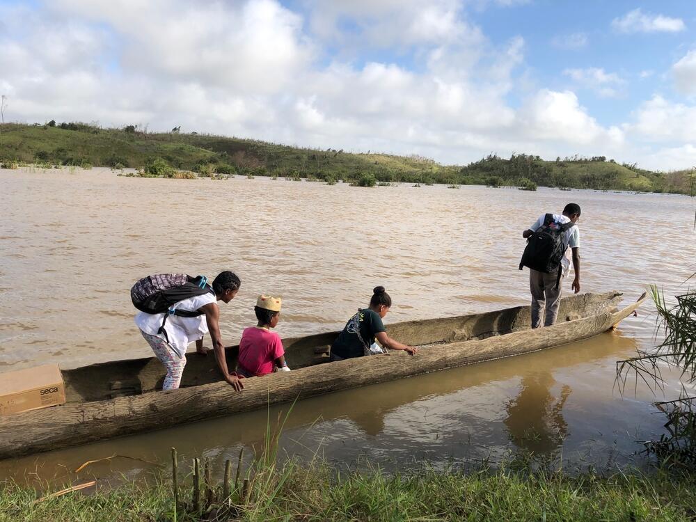 An MSF outreach team crossing a river in a dugout canoe