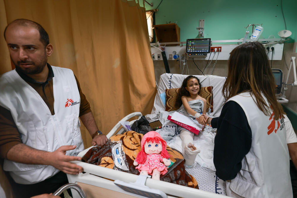 At Al Aqsa Hospital, an MSF psychologist talks to a young girl who lost her entire family in a bomb blast and has been in the hospital since