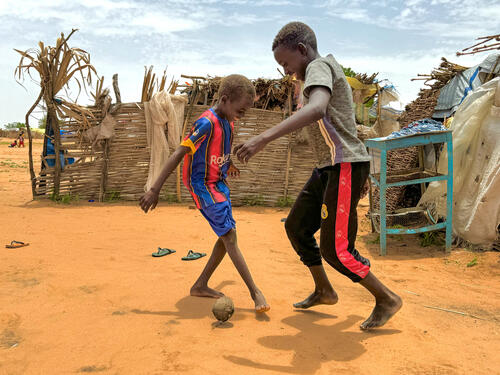 Scene of two boys playing football with bare feet