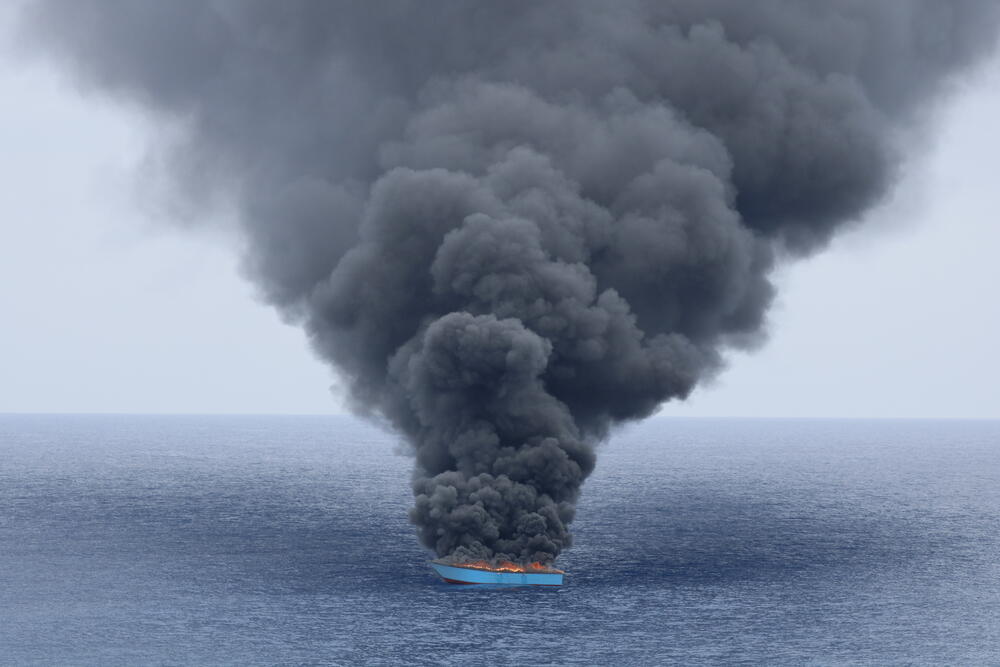 A wooden boat, originally carrying 50 people, that was intercepted and then set on fire by the Libyan Coast Guard