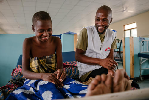 Esther, an advanced HIV patient interacting with Moses Luhanga, MSF Information Education and Communication Manager. In the picture, Moses is finding out how Esther is feeling.