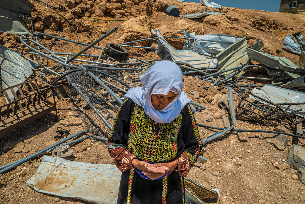 Safa, a resident of Masafer Yatta, stands in front of her demolished home