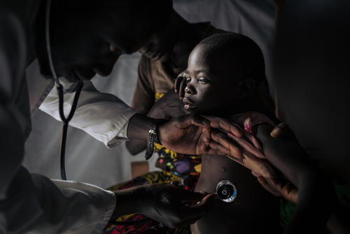 An MSF medic examines a five year old child at the Measles Unit in Biringi Hospital, Ituri, DRC