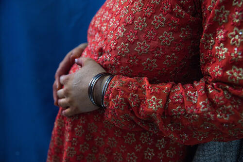 Photo of a pregnant woman resting her hands on her belly