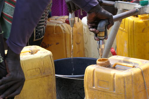 Residents of Bentiu camp filling containers at a water point