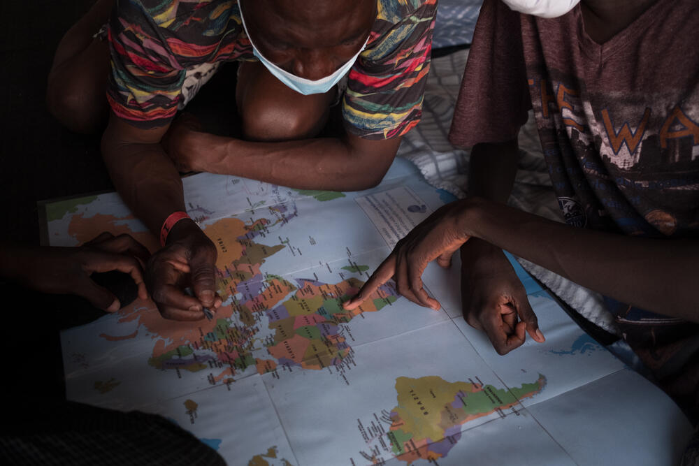 A group of survivors on board the Geo Barents rescue ship show their journeys through Libya on a map