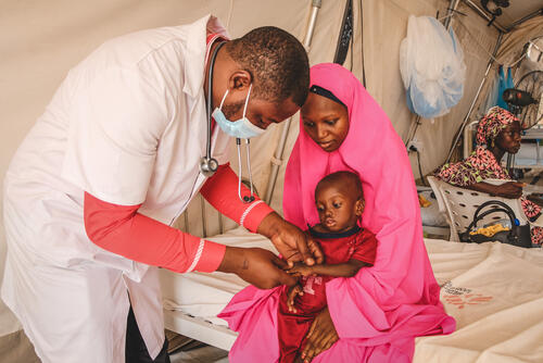 An MSF doctor Ibrahim Fori Bwala examines Ja’afar Ahmed, a severely malnourished child admitted to the inpatient therapeutic feeding centre (ITFC) at Nilefa Kiji nutrition hospital run by MSF in Maiduguri, Borno State in Nigeria.