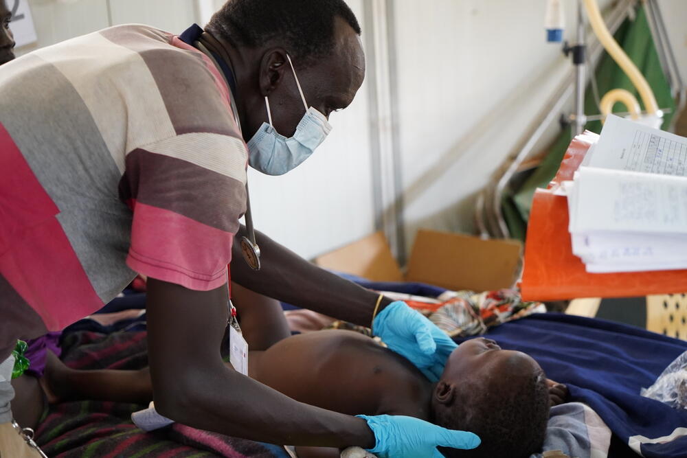 MSF clinical officer, Riak Machar Weinyang, examines a young child in the paediatrics ward of the MSF hospital in Bentiu camp. 