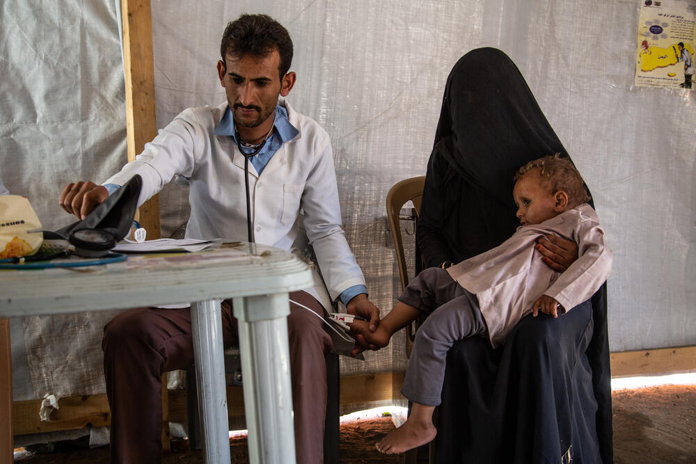 Dr Fouad with a mother and her child inside the triage zone of Haydan hospital in 2019.