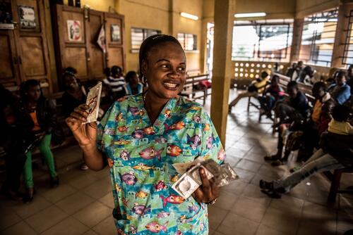 MSF team member Clotilde Manzeza Bilala speaking to HIV patients in a Kinshasa hospital waiting room