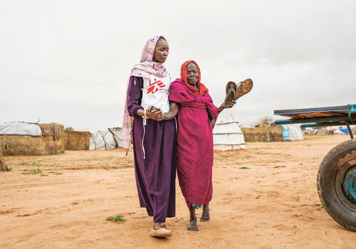 Chad: medical care in a conflict Health promoter Aisha B. (28) accompanies 80 years old Aisha G. to the MSF clinic in Adré transit camp, eastern Chad.
