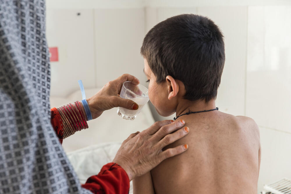 Saed Bibi giving a glass of milk to her 10-year-old son, Saddiqulah, who is being treated for measles at Boost Hospital in Lashkar Gah, Afghanistan