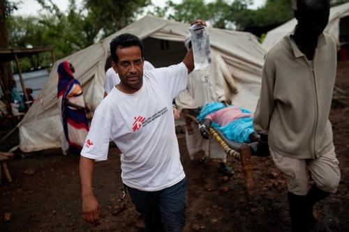 At MSF's out-patient department in Batil refugee camp Gandhi Pant, a nurse, escorts a patient with a possible appendicitis to a waiting ambulance. 

Batil is one of three camps in South Sudan’s Upper Nile State sheltering at least 113,000 refugees who have crossed the border from Blue Nile state to escape fighting between the Sudanese Armed Forces and the SPLM-North armed group. Refugees arrive at the camp with harrowing stories of being bombed out of their homes, or having their villages burned. The camps into which they have poured are on a vast floodplain, leaving many tents flooded and refugees vulnerable to disease. Mortality rates in Batil camp are at emergency levels, malnutrition rates are more than five times above emergency thresholds, and diarrhea and malarial cases are rising.