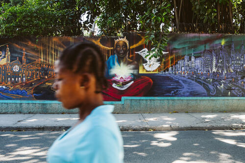 A woman walks past a mural in Bois-Verna