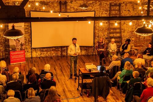 Orzubek Qalandarov speaking onstage