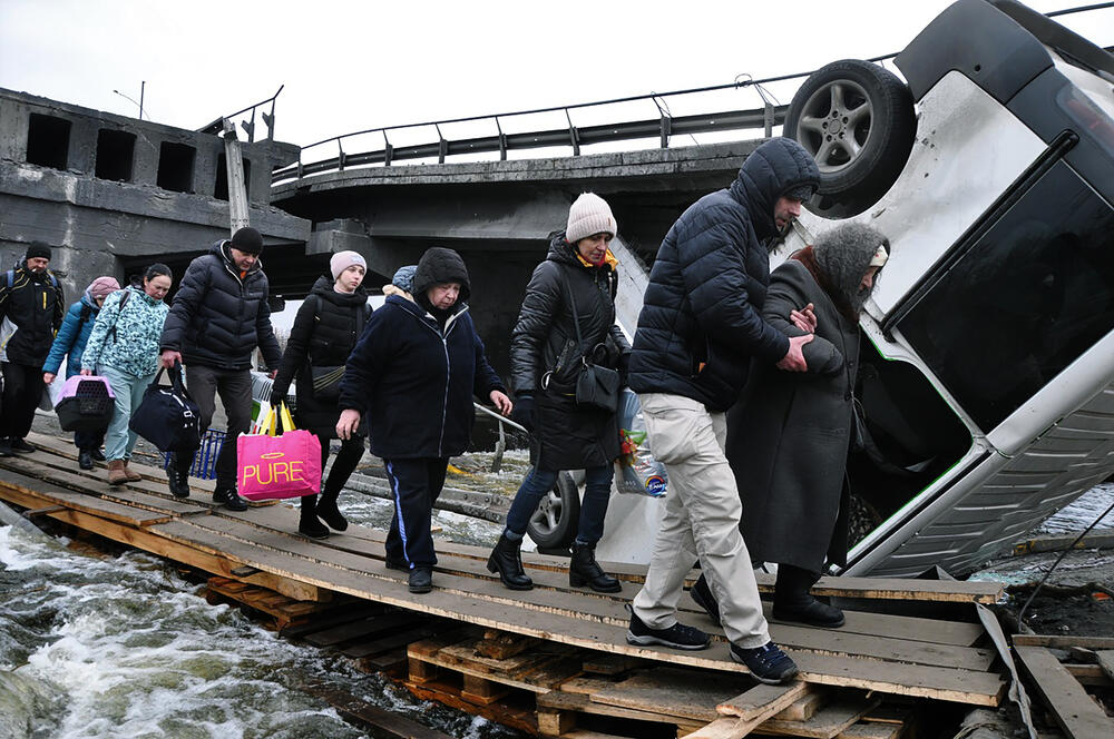 Families fleeing the war cross the Irpin River, northwest of Kyiv. 