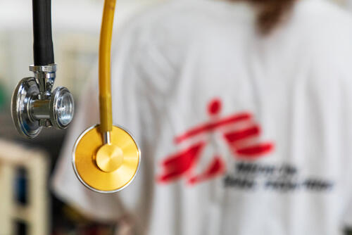 A stethoscope hangs behind an MSF medic