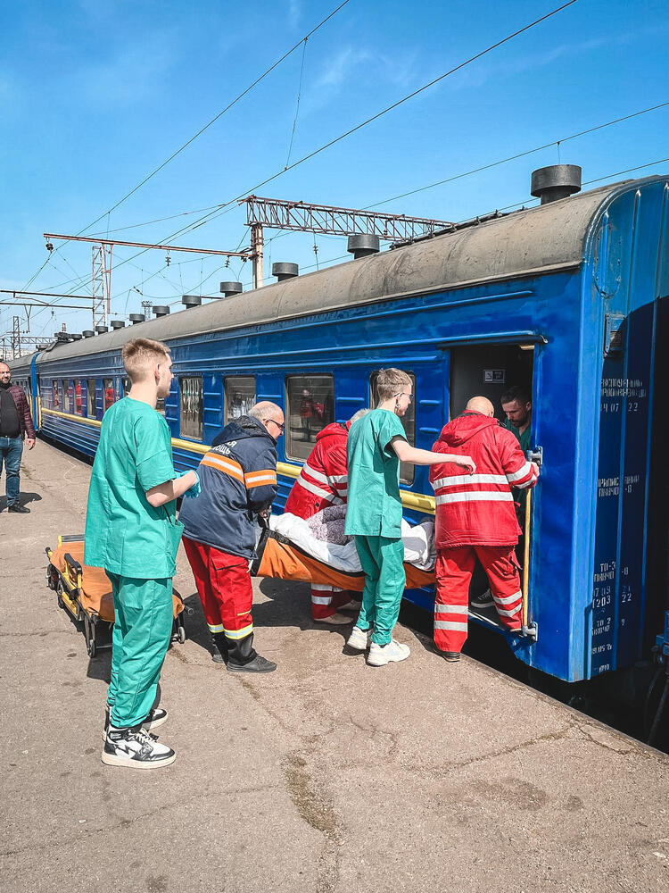 Patients being carried onto the medical train before heading to Lviv