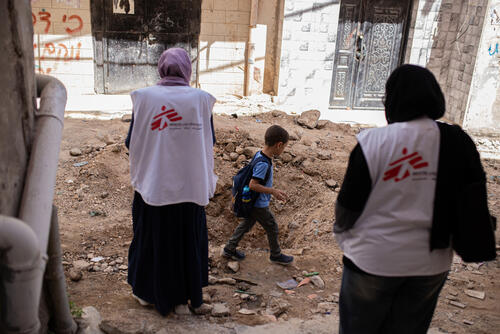 Two mental health first aiders in the West Bank with a child