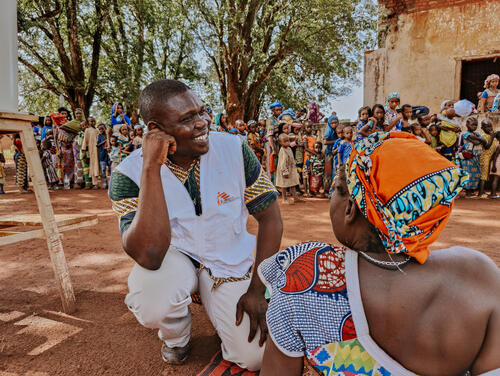 MSF medic Pelé Hubert Kotho-Gawe speaking to a patient at an immunisation event in Ippy