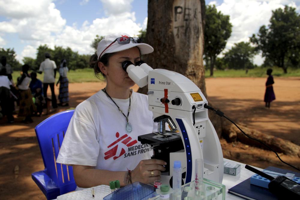 MSF biomedical scientist Fabiola looks at a suspected case of sleeping sickness under the microscope in MSF's mobile laboratory.