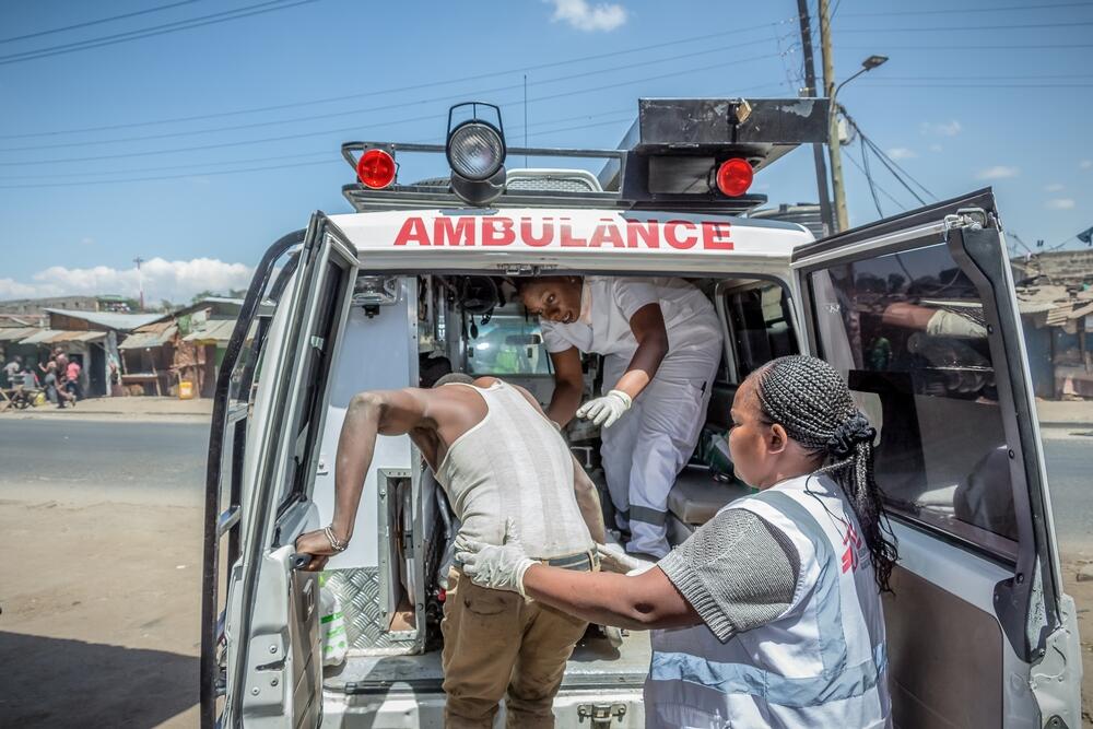 MSF staff help a patient into an ambulance in Nairobi