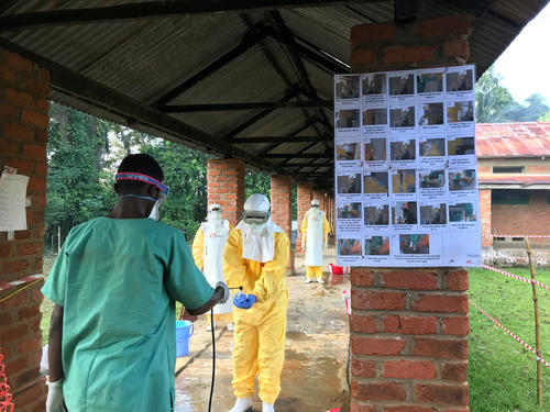 A MSF staff member dressed in full personal protective equipment is disinfected at the Ebola Treatment Centre in Bikoro, Equateur Province, DRC.