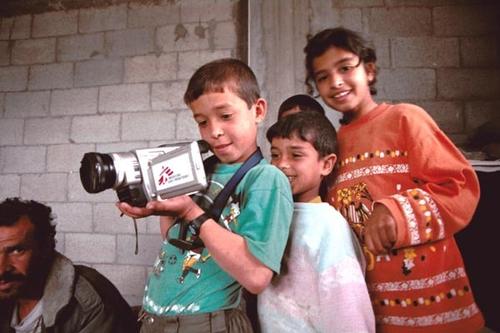 Palestinian children holding an MSF video camera.