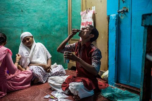 Extensively drug-resistant TB patient Hanif, taking his daily TB medication including the new drugs, at home in the Govandi area of Mumbai, India.