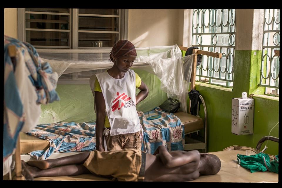 MSF Staff in Dzaipi Hospital Uganda standing at the bed of an ill boy