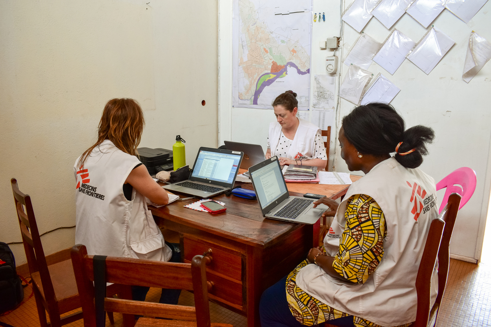 Trois membres du personnel de MSF travaillant sur des ordinateurs portables