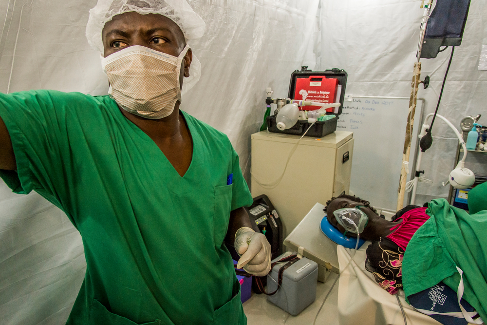 An anesthetist checks his equipment and monitors a screen
