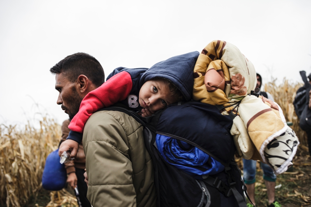 Uprchlík z Iráku kráčí se synem na zádech k srbsko-chorvatské hranici na přechodu Bapska.