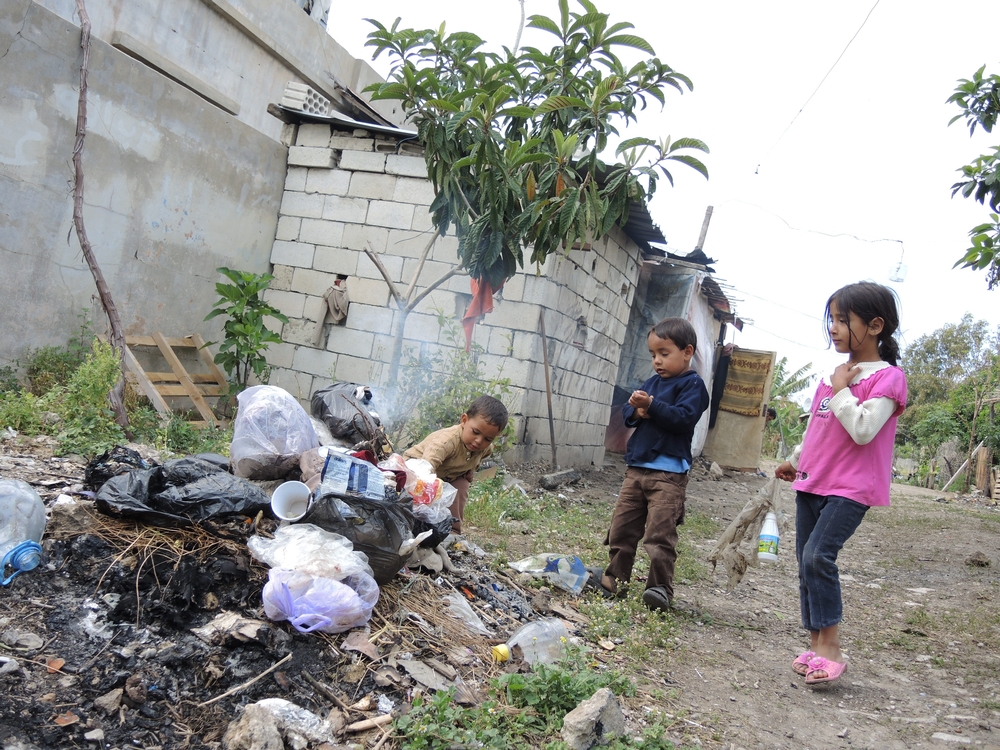 Děti syrských uprchlíků hrající si s odpadky v uprchlickém táboře v libanonském městě Saida.
